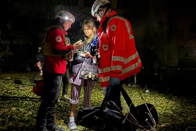 Medical workers talk with a local resident following a Russian missile attack of residential buildings in Zaporizhzhia, on October 17, 2026, amid the Russian invasion of Ukraine. (Photo by Daria Nazarova / AFP)