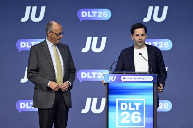 German Chancellor Friedrich Merz (L) listens to Johannes Winkel, Chairman of the Junge Union (JU), which is the youth organization of Germany's conservative Christian Democratic Union (CDU) party, at the JU's Deutschlandtag congress in Bonn, western Germany on October 17, 2026. (Photo by INA FASSBENDER / AFP)