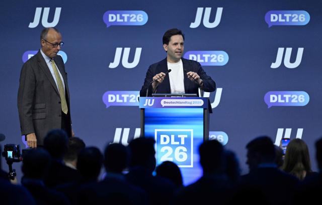 German Chancellor Friedrich Merz (L) listens to Johannes Winkel, Chairman of the Junge Union (JU), which is the youth organization of Germany's conservative Christian Democratic Union (CDU) party, at the JU's Deutschlandtag congress in Bonn, western Germany on October 17, 2026. (Photo by INA FASSBENDER / AFP)