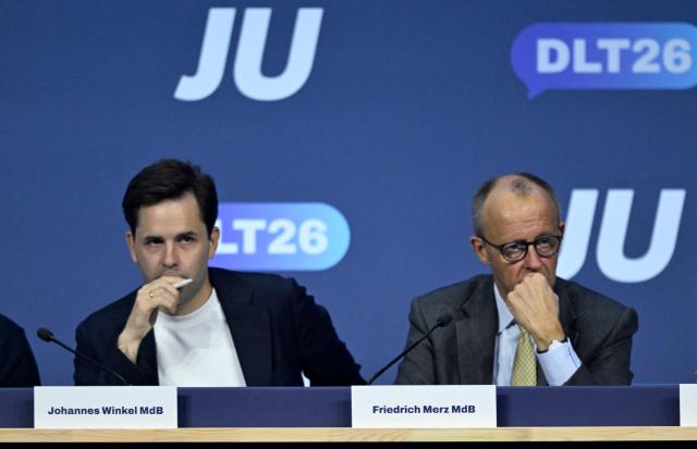 German Chancellor Friedrich Merz (R) sits next to Johannes Winkel, Chairman of the Junge Union (JU), which is the youth organization of Germany's conservative Christian Democratic Union (CDU) party, at the JU's Deutschlandtag congress in Bonn, western Germany on October 17, 2026. (Photo by INA FASSBENDER / AFP)