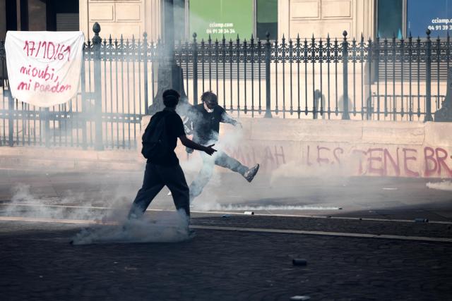 Protesters react among tear gas prior to the start of a demonstration to protest against the "high cost of living", in Marseille, southern France, on October 17, 2026 as part of a nationwide call for mobilisation bringing together various groups expressing their anger: former "Yellow Vests", secondary school and university students, climate activists and even farmers. After weeks of student protests, France faces broader, nationwide demonstrations on October 17, 2026 over the cost of living, setting up a potentially fraught six months heading into a presidential election. A police source told AFP that authorities estimated nearly 200,000 people could take part, with 40,000 in Paris. (Photo by Thibaud MORITZ / AFP)