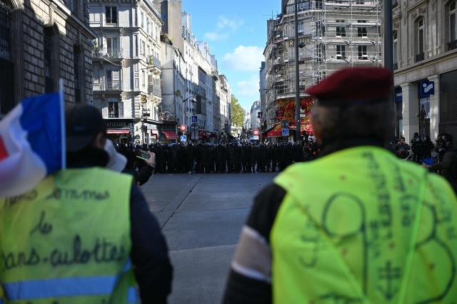 Protesters wearing yello vests face gendarmes as clashes erupt ahead of a demonstration to protest against the "high cost of living", at Place de la Republique in Paris on October 17, 2026 as part of a nationwide call for mobilisation bringing together various groups expressing their anger: former "Yellow Vests", secondary school and university students, climate activists and even farmers. After weeks of student protests, France faces broader, nationwide demonstrations on October 17, 2026 over the cost of living, setting up a potentially fraught six months heading into a presidential election. A police source told AFP that authorities estimated nearly 200,000 people could take part, with 40,000 in Paris. (Photo by Matthieu RONDEL / AFP)