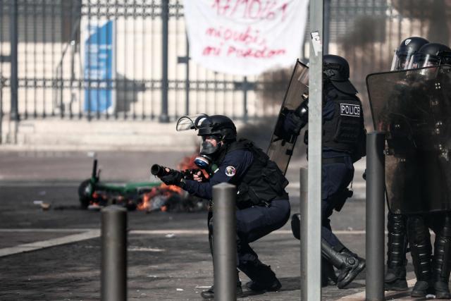 A French national police officer fires tear gas during clashes prior to the start of a demonstration to protest against the "high cost of living", in Marseille, southern France, on October 17, 2026 as part of a nationwide call for mobilisation bringing together various groups expressing their anger: former "Yellow Vests", secondary school and university students, climate activists and even farmers. After weeks of student protests, France faces broader, nationwide demonstrations on October 17, 2026 over the cost of living, setting up a potentially fraught six months heading into a presidential election. A police source told AFP that authorities estimated nearly 200,000 people could take part, with 40,000 in Paris. (Photo by Thibaud MORITZ / AFP)