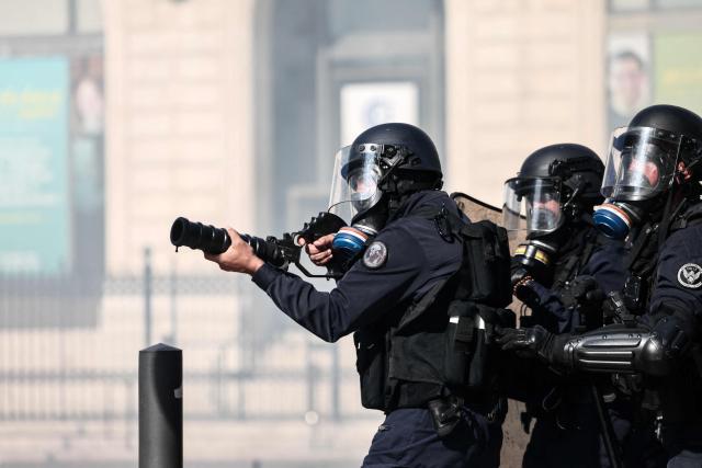 A French national police officer fires tear gas during clashes prior to the start of a demonstration to protest against the "high cost of living", in Marseille, southern France, on October 17, 2026 as part of a nationwide call for mobilisation bringing together various groups expressing their anger: former "Yellow Vests", secondary school and university students, climate activists and even farmers. After weeks of student protests, France faces broader, nationwide demonstrations on October 17, 2026 over the cost of living, setting up a potentially fraught six months heading into a presidential election. A police source told AFP that authorities estimated nearly 200,000 people could take part, with 40,000 in Paris. (Photo by Thibaud MORITZ / AFP)