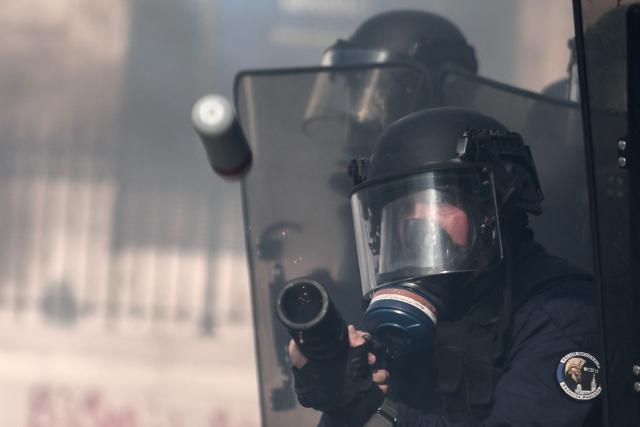 A French national police officer fires tear gas during clashes prior to the start of a demonstration to protest against the "high cost of living", in Marseille, southern France, on October 17, 2026 as part of a nationwide call for mobilisation bringing together various groups expressing their anger: former "Yellow Vests", secondary school and university students, climate activists and even farmers. After weeks of student protests, France faces broader, nationwide demonstrations on October 17, 2026 over the cost of living, setting up a potentially fraught six months heading into a presidential election. A police source told AFP that authorities estimated nearly 200,000 people could take part, with 40,000 in Paris. (Photo by Thibaud MORITZ / AFP)