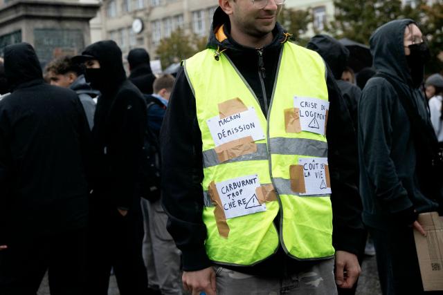 A protester has slogans on his yellow vest during a demonstration against the "high cost of living", in Strasbourg, northeastern France, on October 17, 2026 as part of a nationwide call for mobilisation bringing together various groups expressing their anger: former "Yellow Vests", secondary school and university students, climate activists and even farmers. After weeks of student protests, France faces broader, nationwide demonstrations on October 17, 2026 over the cost of living, setting up a potentially fraught six months heading into a presidential election. A police source told AFP that authorities estimated nearly 200,000 people could take part, with 40,000 in Paris. (Photo by ROMEO BOETZLE / AFP)