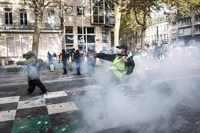 A protester throws a projectile during a demonstration to protest against the "high cost of living", in Lille, northern France, on October 17, 2026 as part of a nationwide call for mobilisation bringing together various groups expressing their anger: former "Yellow Vests", secondary school and university students, climate activists and even farmers. After weeks of student protests, France faces broader, nationwide demonstrations on October 17, 2026 over the cost of living, setting up a potentially fraught six months heading into a presidential election. A police source told AFP that authorities estimated nearly 200,000 people could take part, with 40,000 in Paris. (Photo by Sameer AL-DOUMY / AFP)