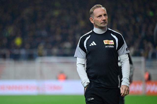 Union Berlin's Swiss head coach Mauro Lustrinelli arrives on the pitch for an interview prior to the German first division Bundesliga football match between Union berlin and Borussia Dortmund in Berlin on October 17, 2026. (Photo by John MACDOUGALL / AFP) / DFL REGULATIONS PROHIBIT ANY USE OF PHOTOGRAPHS AS IMAGE SEQUENCES AND/OR QUASI-VIDEO