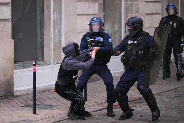 A protester scaffles with anti riot police officers during a demonstration to protest against the "high cost of living", in Bordeaux, southwestern France, on October 17, 2026 as part of a nationwide call for mobilisation bringing together various groups expressing their anger: former "Yellow Vest", secondary school and university students, climate activists and even farmers. After weeks of student protests, France faces broader, nationwide demonstrations on October 17, 2026 over the cost of living, setting up a potentially fraught six months heading into a presidential election. A police source told AFP that authorities estimated nearly 200,000 people could take part, with 40,000 in Paris. (Photo by Christophe ARCHAMBAULT / AFP)