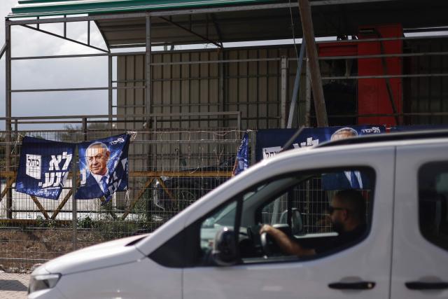 A man drives his vehicle past election campaign posters for Israel's Prime Minister and head of the Likud party Benjamin Netanyahu in the Druze village of Buqata in the Israel-annexed Golan Heights on October 17, 2026. Israel heads to the polls on October 27 in its first election since the October 7, 2023 Hamas-led attack, in what is seen as a referendum on the prime minister. (Photo by Jalaa MAREY / AFP)