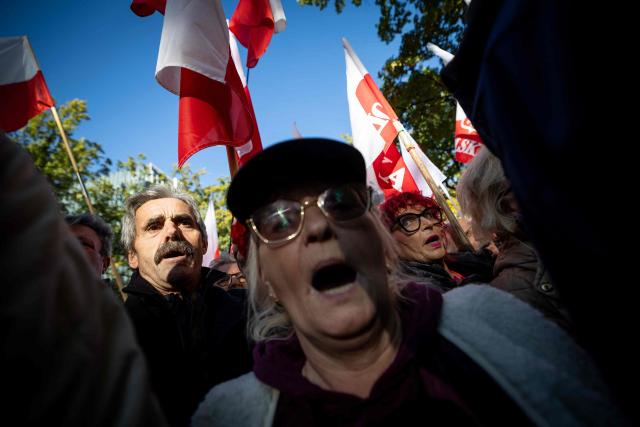 Participants hold Poland's national flags and placards during an anti-government demonstration in front of the Constitutional Court in Warsaw on October 17, 2026. Right wing demonstrators hold a camp protest outside the building of the Constitutional Court in Poland in protest against the nomination of new judges and in defence of those appointed by the previous government of the Law and Justice Party (PiS). (Photo by Wojtek RADWANSKI / AFP)