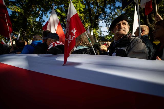 Participants hold Poland's national flags and placards during an anti-government demonstration in front of the Constitutional Court in Warsaw on October 17, 2026. Right wing demonstrators hold a camp protest outside the building of the Constitutional Court in Poland in protest against the nomination of new judges and in defence of those appointed by the previous government of the Law and Justice Party (PiS). (Photo by Wojtek RADWANSKI / AFP)