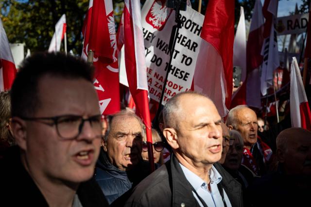 Participants hold Poland's national flags and placards during an anti-government demonstration in front of the Constitutional Court in Warsaw on October 17, 2026. Right wing demonstrators hold a camp protest outside the building of the Constitutional Court in Poland in protest against the nomination of new judges and in defence of those appointed by the previous government of the Law and Justice Party (PiS). (Photo by Wojtek RADWANSKI / AFP)