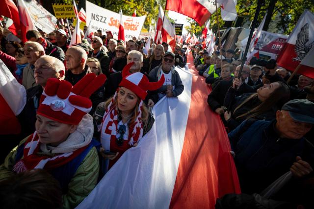 Participants hold Poland's national flags and placards during an anti-government demonstration in front of the Constitutional Court in Warsaw on October 17, 2026. Right wing demonstrators hold a camp protest outside the building of the Constitutional Court in Poland in protest against the nomination of new judges and in defence of those appointed by the previous government of the Law and Justice Party (PiS). (Photo by Wojtek RADWANSKI / AFP)