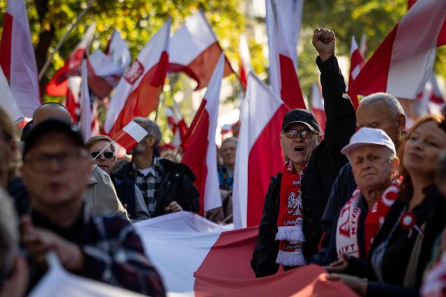 Participants hold Poland's national flags and placards during an anti-government demonstration in front of the Constitutional Court in Warsaw on October 17, 2026. Right wing demonstrators hold a camp protest outside the building of the Constitutional Court in Poland in protest against the nomination of new judges and in defence of those appointed by the previous government of the Law and Justice Party (PiS). (Photo by Wojtek RADWANSKI / AFP)