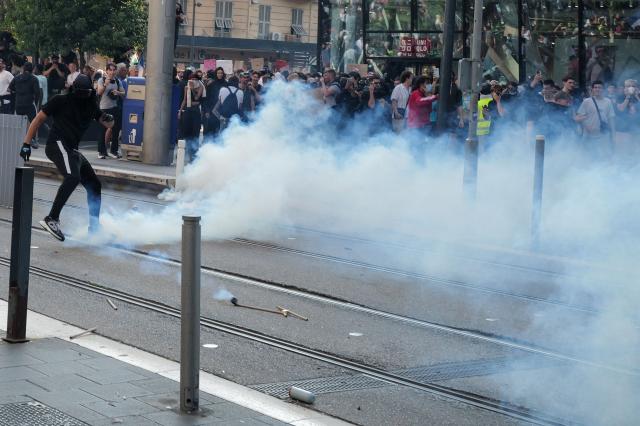 A protester kicks a teargas fired by the police during a demonstration to protest against the "high cost of living", in Nice, southern France, on October 17, 2026 as part of a nationwide call for mobilisation bringing together various groups expressing their anger: former "Yellow Vest", secondary school and university students, climate activists and even farmers. After weeks of student protests, France faces broader, nationwide demonstrations on October 17, 2026 over the cost of living, setting up a potentially fraught six months heading into a presidential election. A police source told AFP that authorities estimated nearly 200,000 people could take part, with 40,000 in Paris. (Photo by Valery HACHE / AFP)