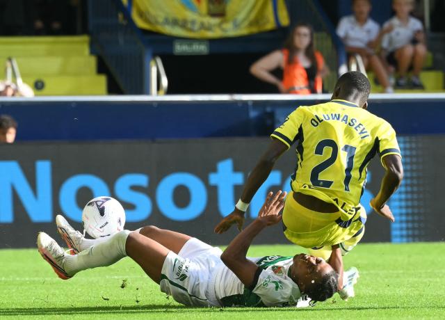 Elche's Spanish defender #02 Buba Sangare falls while fighting for the ball with Villarreal's Canadian forward #21 Tani Oluwaseyi during the Spanish league football match between Villarreal CF and Elche CF at La Ceramica Stadium in Vila-real on October 17, 2026. (Photo by JOSE JORDAN / AFP)