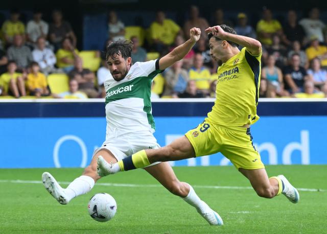TOPSHOT - Villarreal's Georgian forward #09 Georges Mikautadze fights for the ball with Elche's Spanish defender #23 Victor Chust during the Spanish league football match between Villarreal CF and Elche CF at La Ceramica Stadium in Vila-real on October 17, 2026. (Photo by JOSE JORDAN / AFP)