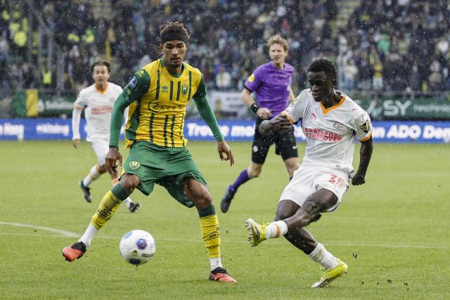 ADO Den Haag's Danish defender Jonas Jensen-Abbew fights for the ball with PSV Eindhoven's Dutch midfielder #35 Ayoni Santos during the Dutch Eredivisie football match between ADO Den Haag and PSV Eindhoven at the WerkTalent Stadion in The Hague on October 17, 2026. (Photo by Bas Czerwinski / ANP / AFP) / Netherlands OUT