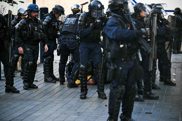 French Republican Security Corps (CRS - Compagnies Republicaines de Securite) detain a protestor during a demonstration to protest against the "high cost of living", in Bordeaux, southwestern France, on October 17, 2026 as part of a nationwide call for mobilisation bringing together various groups expressing their anger: former "Yellow Vest", secondary school and university students, climate activists and even farmers. After weeks of student protests, France faces broader, nationwide demonstrations on October 17, 2026 over the cost of living, setting up a potentially fraught six months heading into a presidential election. A police source told AFP that authorities estimated nearly 200,000 people could take part, with 40,000 in Paris. (Photo by Christophe ARCHAMBAULT / AFP)
