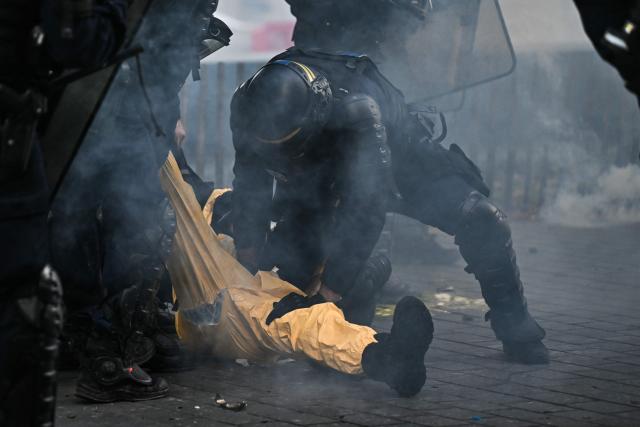 French Republican Security Corps (CRS - Compagnies Republicaines de Securite) detain a protestor during a demonstration to protest against the "high cost of living", in Bordeaux, southwestern France, on October 17, 2026 as part of a nationwide call for mobilisation bringing together various groups expressing their anger: former "Yellow Vest", secondary school and university students, climate activists and even farmers. After weeks of student protests, France faces broader, nationwide demonstrations on October 17, 2026 over the cost of living, setting up a potentially fraught six months heading into a presidential election. A police source told AFP that authorities estimated nearly 200,000 people could take part, with 40,000 in Paris. (Photo by Christophe ARCHAMBAULT / AFP)