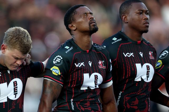 South Africa's Morne Van Den Berg (L) and other Lions players observe a moment of silence in honour of their teammate Hyron Andrews ahead of the European Rugby Champions Cup rugby union match between Stade Rochelais (La Rochelle) and Lions at at the Marcel-Deflandre Stadium in La Rochelle, western France, on October 17, 2026. South African second row Hyron Andrews of Johannesburg-based side the Lions was found dead at a hotel in France on October 16, on the eve of his team's Champions Cup match against La Rochelle, local authorities told AFP. (Photo by ROMAIN PERROCHEAU / AFP)
