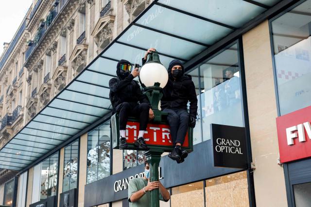 Protesters sit on a metro pillar during a demonstration against the "high cost of living", in Paris on October 17, 2026 as part of a nationwide call for mobilisation bringing together various groups expressing their anger: former "Yellow Vest", secondary school and university students, climate activists and even farmers. After weeks of student protests, France faces broader, nationwide demonstrations on October 17, 2026 over the cost of living, setting up a potentially fraught six months heading into a presidential election. A police source told AFP that authorities estimated nearly 200,000 people could take part, with 40,000 in Paris. (Photo by GEOFFROY VAN DER HASSELT / AFP)