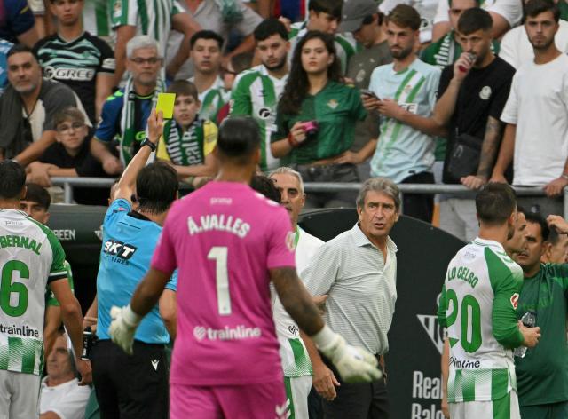 Real Betis' Chilean coach Manuel Pellegrini is shown a yellow card during the Spanish league football match between Real Betis and FC Barcelona at La Cartuja stadium in Seville on October 17, 2026. (Photo by JORGE GUERRERO / AFP)