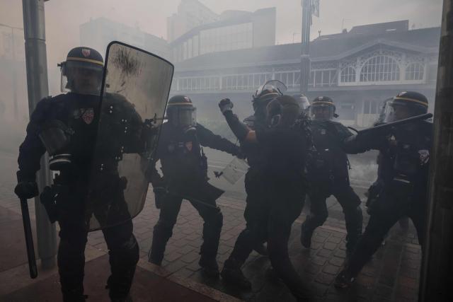 French Republican Security Corps (CRS - Compagnies Republicaines de Securite) police officers clash with a protester amid tear gas during a demonstration against the "high cost of living", in Toulouse, southwestern France, on October 17, 2026 as part of a nationwide call for mobilisation bringing together various groups expressing their anger: former "Yellow Vest", secondary school and university students, climate activists and even farmers. After weeks of student protests, France faces broader, nationwide demonstrations on October 17, 2026 over the cost of living, setting up a potentially fraught six months heading into a presidential election. A police source told AFP that authorities estimated nearly 200,000 people could take part, with 40,000 in Paris. (Photo by Ed JONES / AFP)