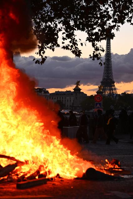 A fire is seen with the Eiffel Tower in the background during a demonstration to protest against the "high cost of living", in Paris on October 17, 2026 as part of a nationwide call for mobilisation bringing together various groups expressing their anger: former "Yellow Vest", secondary school and university students, climate activists and even farmers. After weeks of student protests, France faces broader, nationwide demonstrations on October 17, 2026 over the cost of living, setting up a potentially fraught six months heading into a presidential election. A police source told AFP that authorities estimated nearly 200,000 people could take part, with 40,000 in Paris. (Photo by Guillaume Saligot / AFP)