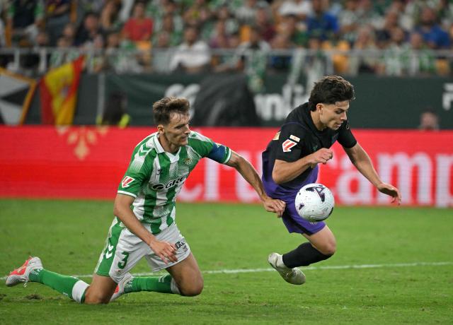 Real Betis' Spanish defender #03 Diego Llorente fights for the ball with Barcelona's Spanish defender #12 Xavi Espart during the Spanish league football match between Real Betis and FC Barcelona at La Cartuja stadium in Seville on October 17, 2026. (Photo by JORGE GUERRERO / AFP)