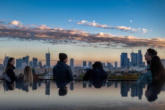 People visit the rooftop of the Forest Campus office building during the annual Night of Skyscrapers, an event that opens the rooftops of Warsaw's tallest buildings to the public, offering a unique perspective on the city skyline, in Warsaw on October 17, 2026. (Photo by Sergei GAPON / AFP)