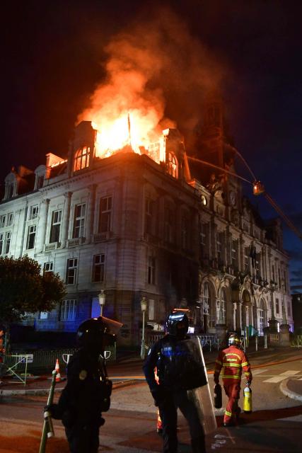 This photograph shows a fire burning at the city hall after a group of individuals forced entry into the building during ongoing protest action against the "high cost of living", in Limoges, central France on October 17, 2026 as part of a nationwide call for mobilisation bringing together various groups expressing their anger: former "Yellow Vest", secondary school and university students, climate activists and even farmers. After weeks of student protests, France faces broader, nationwide demonstrations on October 17, 2026 over the cost of living, setting up a potentially fraught six months heading into a presidential election. A police source told AFP that authorities estimated nearly 200,000 people could take part, with 40,000 in Paris. (Photo by Pascal LACHENAUD / AFP)