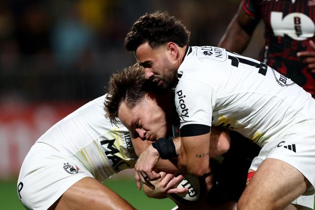 Lions' South African full back Quan Horn (C) is tackled by La Rochelle's French fly half Antoine Hastoy (R) during the European Rugby Champions Cup rugby union match between Stade Rochelais (La Rochelle) and Lions at at the Marcel-Deflandre Stadium in La Rochelle, western France, on October 17, 2026. (Photo by ROMAIN PERROCHEAU / AFP)