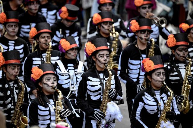 Musicians perform during the Alebrijes Parade ahead of Day of the Dead celebrations in Mexico City on October 17, 2026. The Alebrijes Parade is an annual event celebrating Mexican folk art and handicrafts, during which giant mythical creatures made of "cartoneria" (a form of papier-mache) are paraded from Mexico City's Zocalo through the capital's main avenues to the Angel of Independence, where they remain on display. (Photo by Alfredo ESTRELLA / AFP)