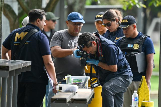 Forensic prosecutors from Guatemala's Public Ministry collect evidence near the body of lawyer Juan Francisco Solorzano Foppa at the Campo Marte sports complex in Guatemala City on October 17, 2026. Former Guatemalan prosecutor who denounced corruption cases and alleged links between gangs and politicians was shot dead in Guatemala City on October 17, 2026, police said. (Photo by Johan ORDONEZ / AFP)