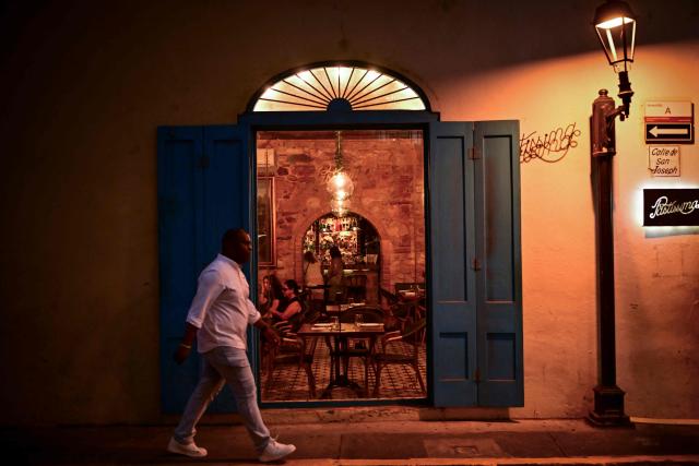 A man walks past a restaurant in Casco Viejo, Panama City, on October 17, 2026. Declared a UNESCO World Heritage Site in 1997, Casco Viejo is one of the main tourist destinations in the Panamanian capital, known for its colonial architecture, historic churches, cultural centers, bars and restaurants. (Photo by MARTIN BERNETTI / AFP)