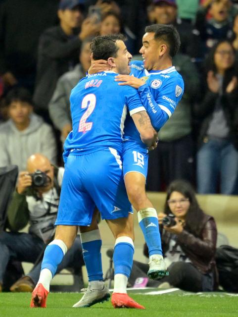 Cruz Azul's midfielder #19 Carlos Rodriguez celebrates with teammate defender #02 Alan Mozo after scoring his team's second goal during the Liga MX Apertura tournament football match between Cruz Azul and Juarez at the Banorte stadium in Mexico City on October 17, 2026. (Photo by Alfredo ESTRELLA / AFP)