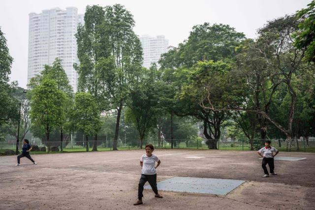 People exercise in a park in Singapore on October 18, 2026, as the country continues to be shrouded in haze caused by fires in Indonesia. Ongoing fires in Indonesia that have blanketed parts of Southeast Asia with toxic haze have triggered the highest-level alert by the regional bloc's climate and fire monitor. (Photo by Yuichi YAMAZAKI / AFP)
