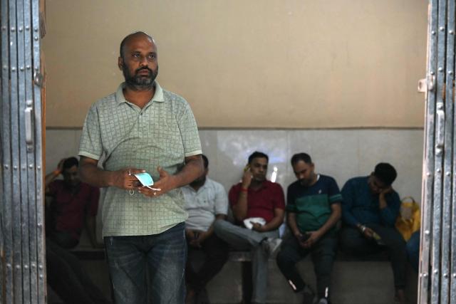 Relatives wait to receive bodies of victims killed in a stampede during a religious gathering, at a government mortuary in Kolkata on October 18, 2026. At least 17 people were killed and two dozen more injured on October 17 in eastern India after a stampede that was likely caused by sudden rainfall during a Hindu religious gathering, officials said. (Photo by Dibyangshu SARKAR / AFP)