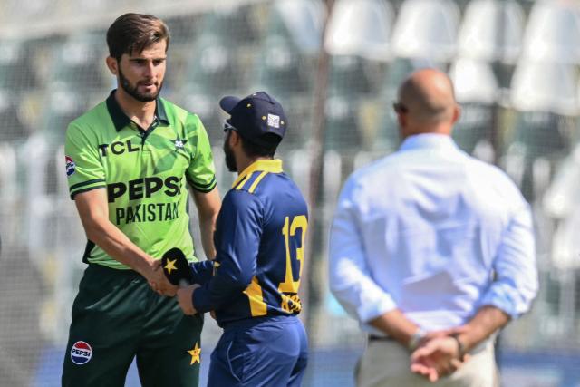Pakistan's captain Shaheen Shah Afridi (L) shakes hands with his Sri Lankan counterpart Kusal Mendis (C) during the toss before the start of the tri-series one-day international (ODI) cricket match between Pakistan and Sri Lanka at the Rawalpindi Cricket Stadium in Rawalpindi on October 18, 2026. (Photo by Aamir QURESHI / AFP)