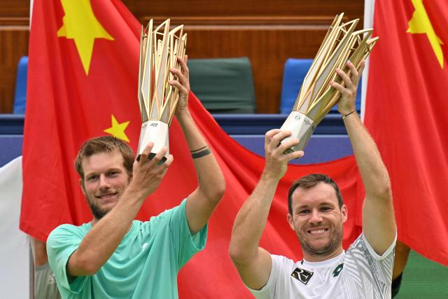 Austria's Neil Oberleitner (L) and Austria's Lucas Miedler (R) celebrate with the trophy after their victory against USA's James Tracy and Portugal's Francisco Cabral in their men's doubles final match at the Shanghai Masters tennis tournament in Shanghai on October 18, 2026. (Photo by HECTOR RETAMAL / AFP)