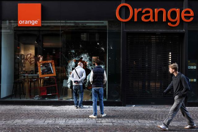 A photograph taken on October 18, 2026 shows
the frontage window of the broken window of an "Orange" telecom shop in Lille, northern France, a day after nationwide protests against the "high cost of living".. France's Prime Minister Sebastien Lecornu said 1,200 people were arrested in protests across the country on October 17, and 150 police were hurt as clashes between police and protesters, massive looting and multiple blazes gripped France as nationwide marches against soaring inflation degenerated into street violence of "extreme intensity". (Photo by Sameer Al-Doumy / AFP)