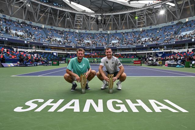 Austria's Neil Oberleitner (L) and Austria's Lucas Miedler (R) pose with the trophy after their victory against USA's James Tracy and Portugal's Francisco Cabral in their men's doubles final match at the Shanghai Masters tennis tournament in Shanghai on October 18, 2026. (Photo by HECTOR RETAMAL / AFP)