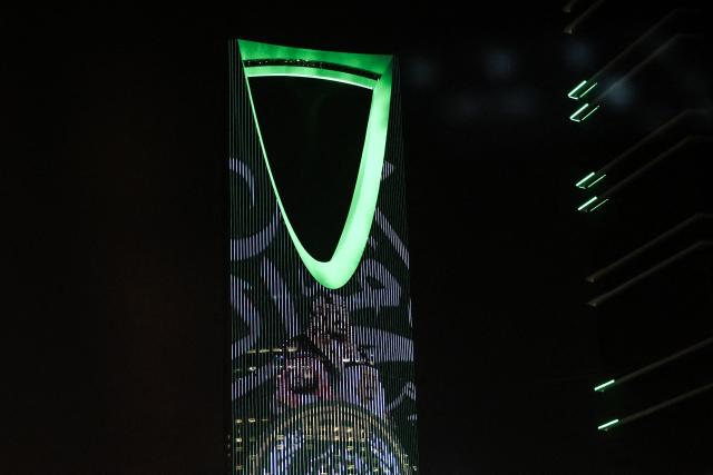 (FILES) The Kingdom Centre skyscraper is illuminated in the colours of the national flag during the 96th Saudi National day celebrations in Riyadh on September 23, 2026. Riyadh's Kingdom Centre skyscraper, one of the city's major landmarks, ordered its office tenants to work remotely "until further notice" on October 18, 2026, after repeated Houthi attacks on Saudi Arabia. "Kindly refrain from attending the offices during this period," the office management said in an email to tenants seen by AFP. The mall at the foot of the 99-storey building remains open. (Photo by Fayez NURELDINE / AFP)