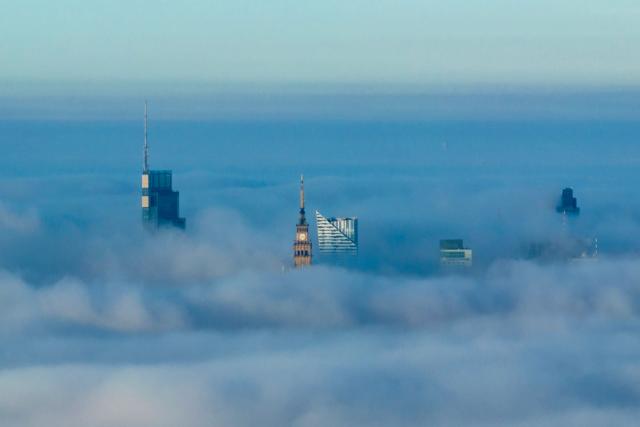 This aerial photograph taken on October 18, 2026 shows Warsaw's skyscrapers shrouded in a blanket of fog on an autumn morning. (Photo by Sergei GAPON / AFP)