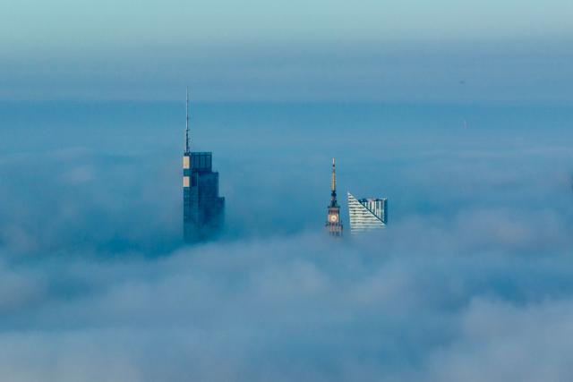 This aerial photograph taken on October 18, 2026 shows Warsaw's skyscrapers shrouded in a blanket of fog on an autumn morning. (Photo by Sergei GAPON / AFP)