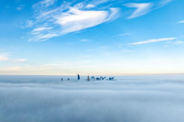 This aerial photograph taken on October 18, 2026 shows Warsaw's skyscrapers shrouded in a blanket of fog on an autumn morning. (Photo by Sergei GAPON / AFP)