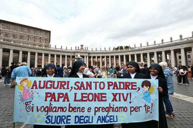A group of nuns hold a banner to greet Pope leo XIV at St. Peter's square before the Angelus prayer a day after the pontiff returns to The Vatican following a surgery to remove a cancerous tumour in his right lung, on October 18, 2026. (Photo by Tiziana FABI / AFP)