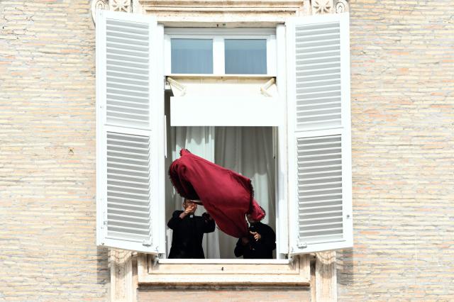 Pope's assistants prepare the window of the Appostolic Palace overlooking St Peter's Square before the Angelus prayer, a day after Pope Leo XIV returns to the Vatican following surgery to remove a cancerous tumour from his right lung, on October 18, 2026. (Photo by Tiziana FABI / AFP)